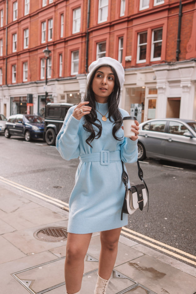 Luxury fashion blogger Shloka Sensarma of the Silk Sneaker styles an & Other Stories belted blue sweater dress with a Prada Sidonie Bag