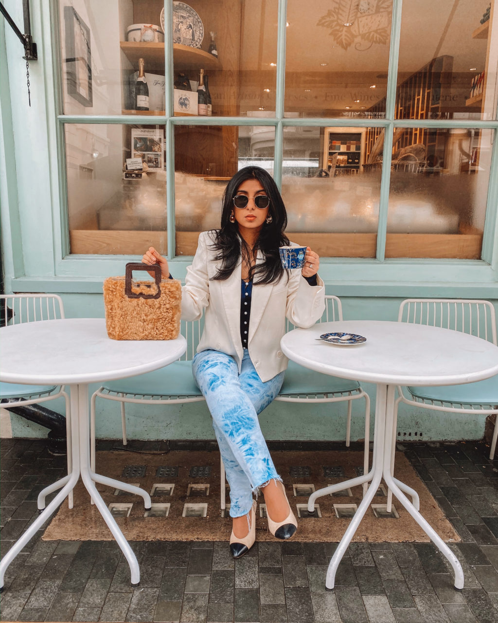 Luxury fashion blogger Shloka Narang of The Silk Sneaker shares an easy winter outfit featuring a Staud bag from Farfetch